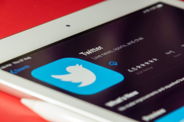 A phone lies horizontally with the Twitter logo visible.